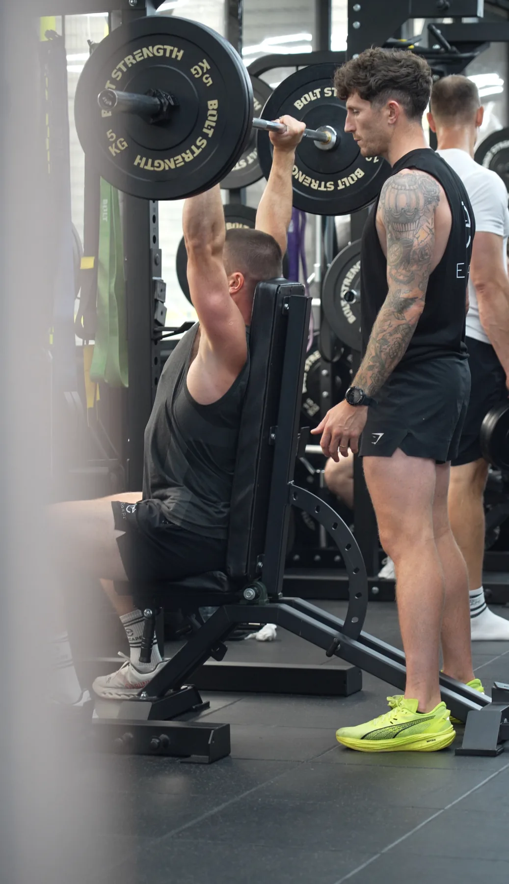 An Excape coach spotting a member on the bench