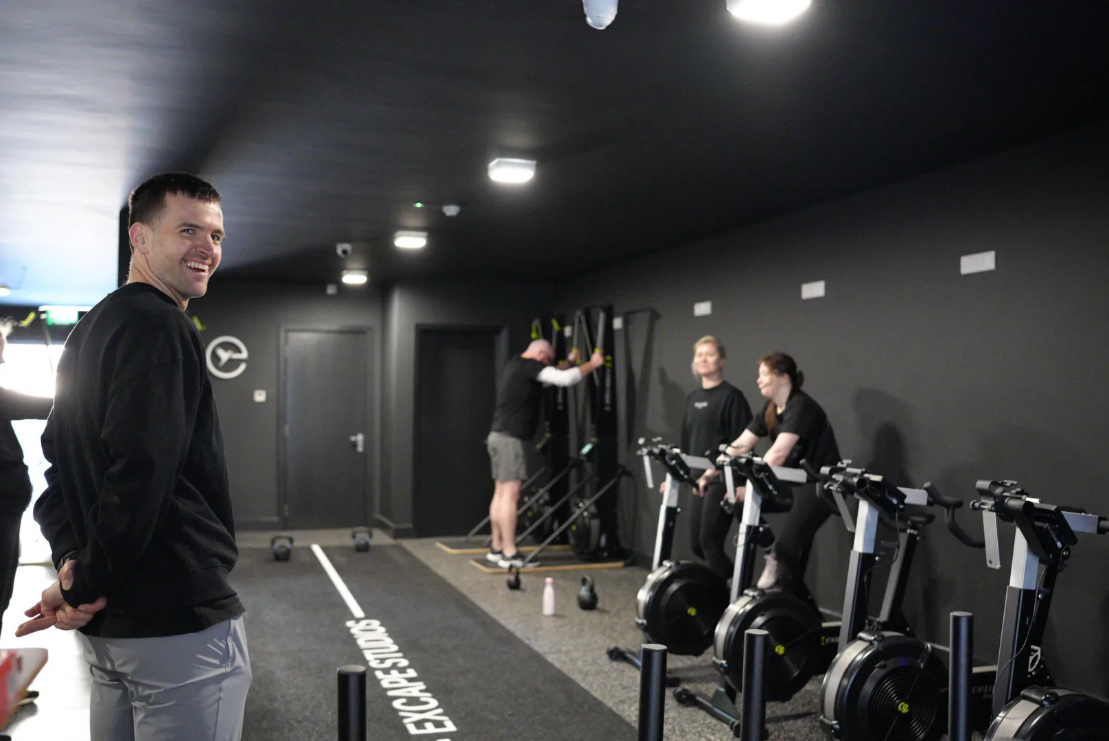 An Excape coach working with a member on the studio floor