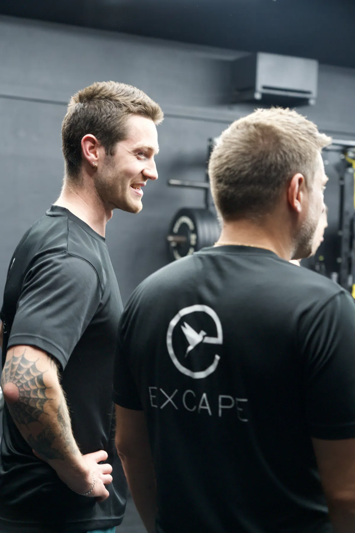 Two Excape coaches talking on the studio floor