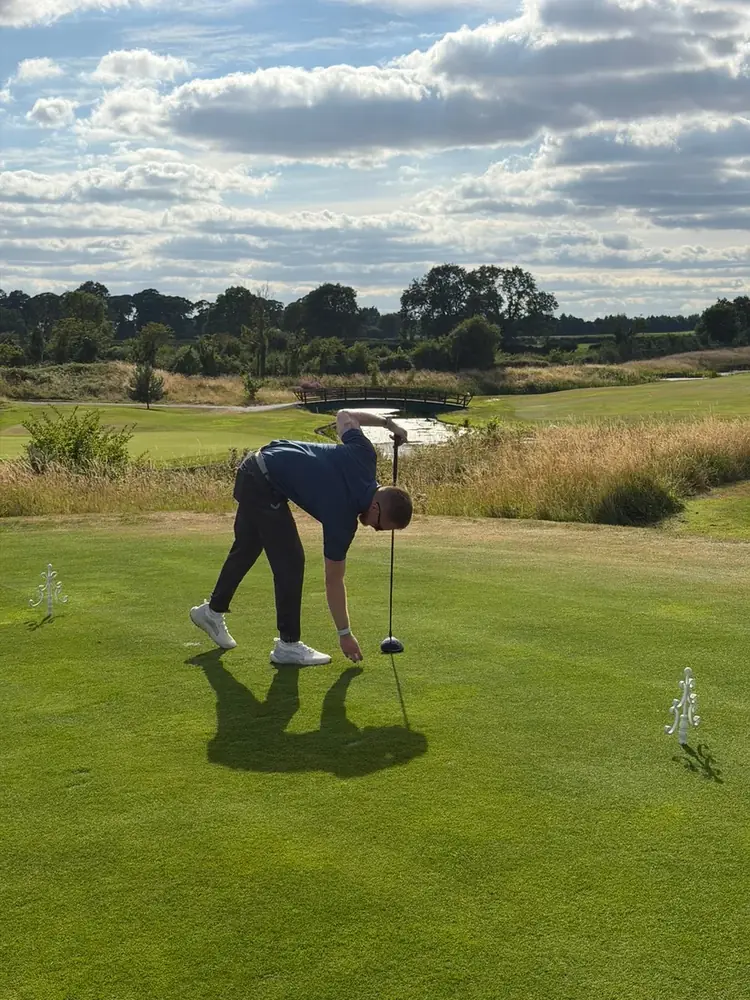 An Excape golf society member putting on the green