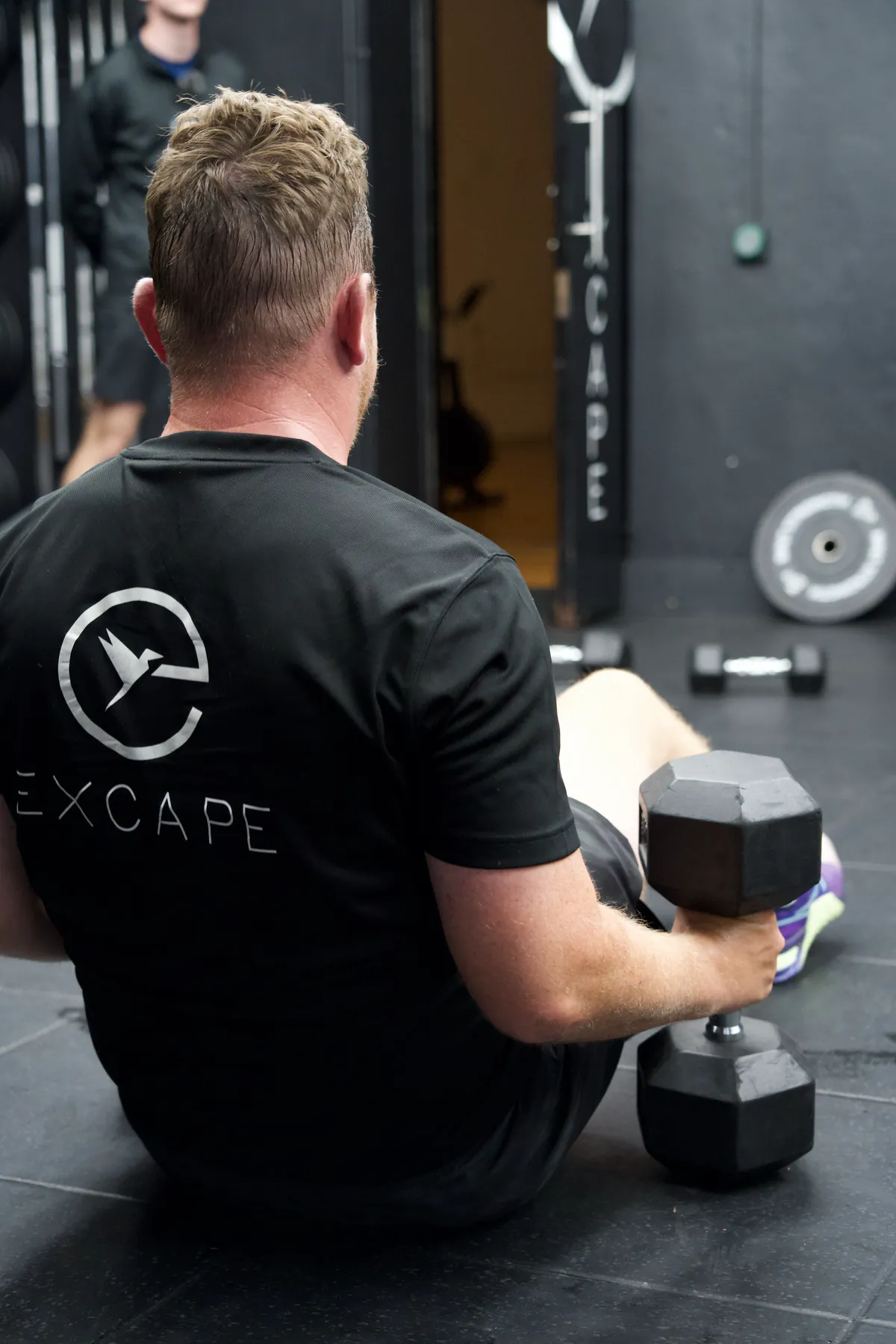 An Excape member working through a dumbbell set
